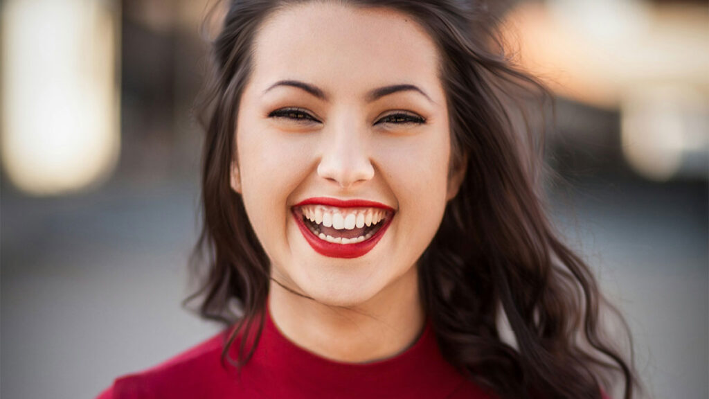 Mulher sorridente simbolizando otimismo e engajamento na liderança da nova geração.