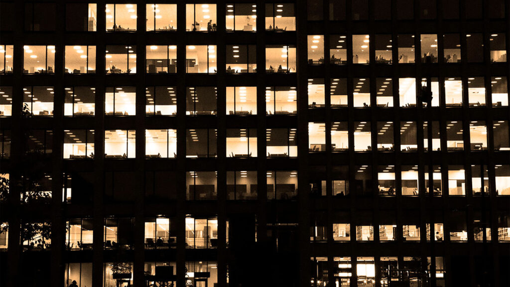 Escritório moderno iluminado à noite, simbolizando a cultura organizacional sustentável e a governança sólida essenciais para a longevidade das empresas.