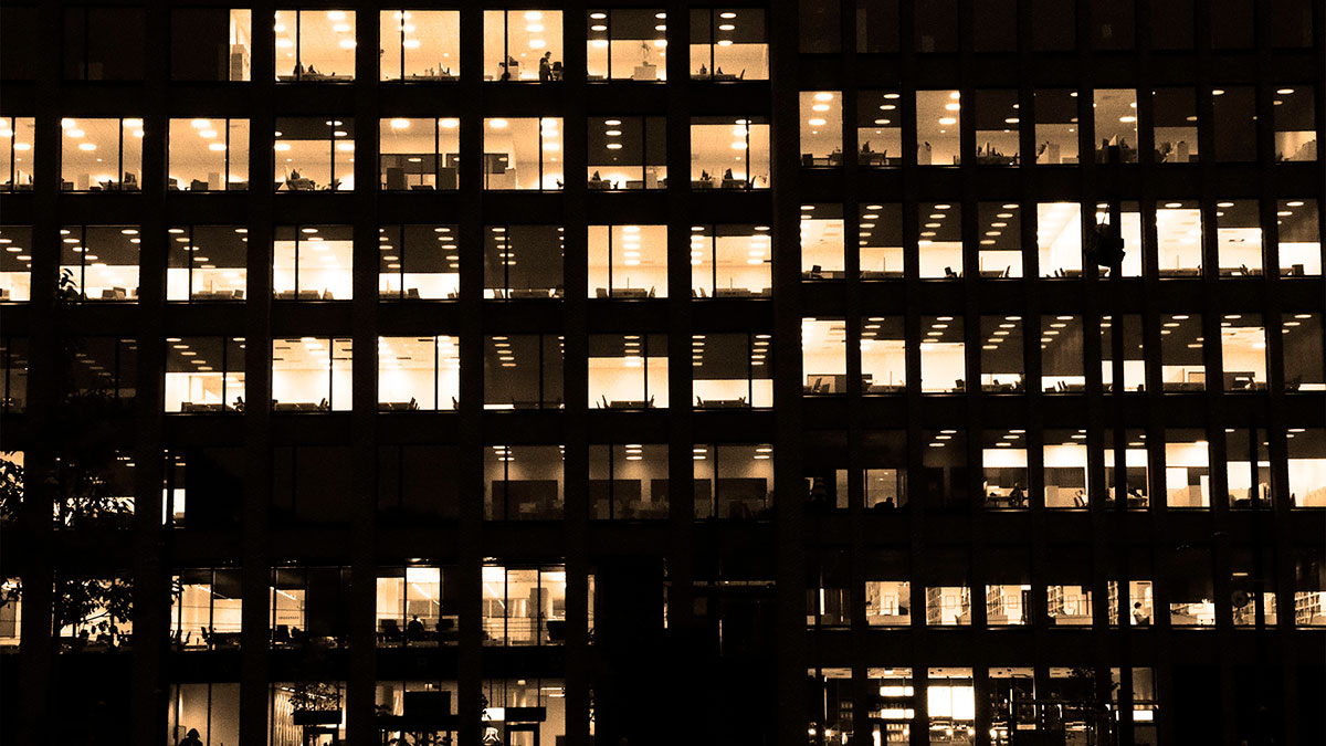 Escritório moderno iluminado à noite, simbolizando a cultura organizacional sustentável e a governança sólida essenciais para a longevidade das empresas.