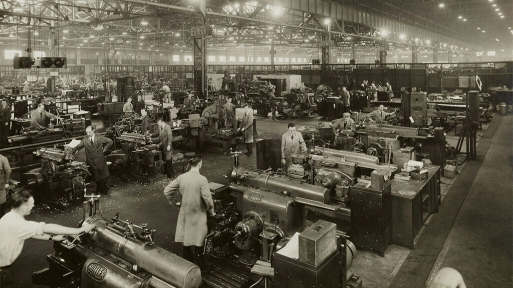 Ambiente de fábrica tradicional com trabalhadores operando máquinas, ilustrando o modelo de gestão tradicional que precisa evoluir para a gestão ESG, focada em sustentabilidade e colaboração.