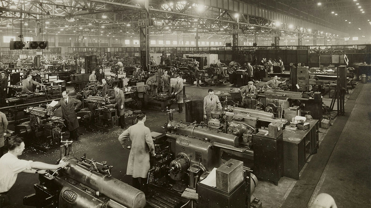 Ambiente de fábrica tradicional com trabalhadores operando máquinas, ilustrando o modelo de gestão tradicional que precisa evoluir para a gestão ESG, focada em sustentabilidade e colaboração.